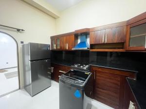 a kitchen with wooden cabinets and a stainless steel refrigerator at Scenic Lanka Luxury Rooms in Dehiwala +4 photos