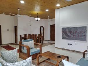 a living room with chairs and a table at Scenic Lanka Luxury Rooms in Dehiwala