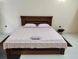 a bedroom with a bed with a wooden headboard at Scenic Lanka Luxury Rooms in Dehiwala