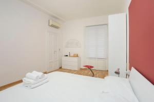 1 dormitorio con cama blanca y pared roja en Monti 29 - Corso Sempione Milano, en Milán