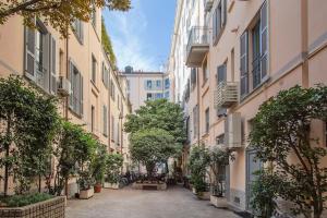 un callejón en una ciudad con edificios y árboles en Monti 29 - Corso Sempione Milano, en Milán