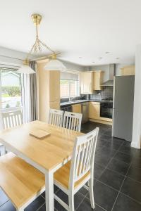 a kitchen and dining room with a wooden table and chairs at 3 Bed Spacious House in Golf Links Road 