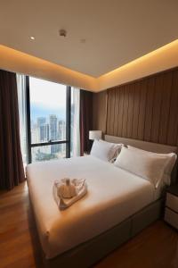 a hotel room with a bed with a towel on it at Ikon Service Apartment at IMPERIAL in Kuala Lumpur