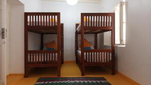 2 literas de madera en una habitación con alfombra en NOMAD Hostel Stone Town, en Zanzíbar