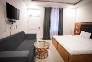 a bedroom with a bed and a couch and a television at Shaanti Coliving in Rishīkesh