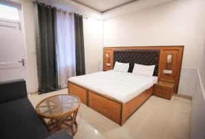 a bedroom with a bed and a chair and a window at Shaanti Coliving in Rishīkesh