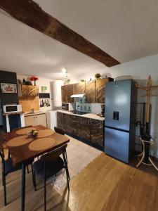una cocina con una mesa y un refrigerador en Toute une Histoire, en Commes