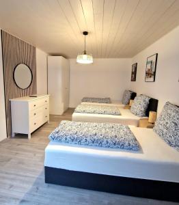 a bedroom with two beds and a dresser at Family Suite del Pueblo in Weiden +7 photos