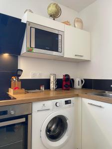 a kitchen with a washing machine and a microwave at Montpellier - Corum - Louis Blanc in Montpellier