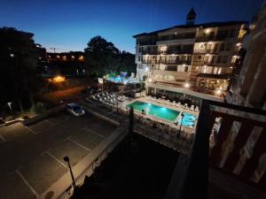 a swimming pool in front of a building at night at Elegant Stay Apartment in Constantine and Helena, Free Parking in Varna City