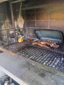 una parrilla con algo de comida encima en Pay huasi cabañas, en El Rincón