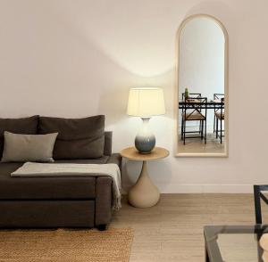 a living room with a couch and a table and a mirror at Canaryislandshost l Orilla in Famara