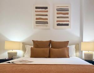 a bedroom with a white bed with two lamps at Canaryislandshost l Orilla in Famara