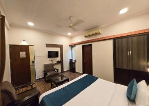 a hotel room with a bed and a chair at HOTEL - VV!NN - Hotel ! Varanasi - Providing Air conditioned & Well Decorated Rooms with Free Wi-Fi - Parking & Restaurant With Lyft Facilities - Best hotel in Varanasi in Rāmnagar