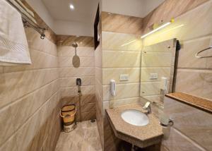 a bathroom with a sink and a shower at HOTEL - VV!NN - Hotel ! Varanasi - Providing Air conditioned & Well Decorated Rooms with Free Wi-Fi - Parking & Restaurant With Lyft Facilities - Best hotel in Varanasi in Rāmnagar +16 photos
