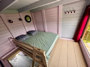a small room with a bed in a shed at le refuge in La Dessaint