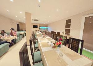a restaurant with long tables and chairs and people eating at HOTEL - VV!NN - Hotel ! Varanasi - Providing Air conditioned & Well Decorated Rooms with Free Wi-Fi - Parking & Restaurant With Lyft Facilities - Best hotel in Varanasi in Rāmnagar