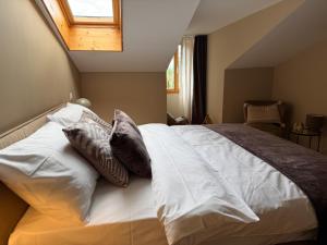 a bedroom with a large bed with pillows on it at Boutique Hotel La Couronne Mies in Mies +2 photos