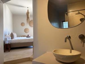a bathroom with a bowl sink and a bedroom at Kokon Boutique Guesthouse in Somerset West