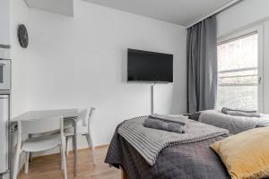 una camera da letto con due letti, un tavolo e una scrivania di Laadukas kalustettu yksiö Logomolla 1-2hlö a Turku