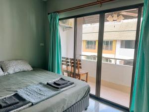 een slaapkamer met een bed en een groot glazen raam bij Orient Hotel in Jomtien Beach