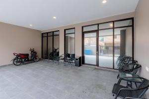 Una habitación con sillas y una moto dentro. en Urbanview Syariah Hotel Senen Jakarta, en Yakarta