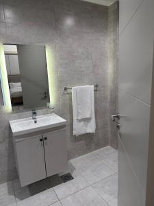 een badkamer met een witte wastafel en een spiegel bij Cloud9 suites - Westlands Road in Nairobi