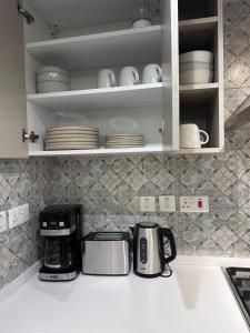 een aanrecht met een koffiezetapparaat en borden bij Cloud9 suites - Westlands Road in Nairobi +1 foto
