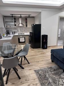 een keuken en woonkamer met een glazen tafel en stoelen bij Cloud9 suites - Westlands Road in Nairobi