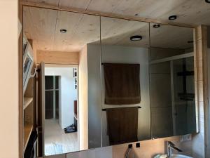 a mirror over a sink in a bathroom at XCUBE Tinyhouse in Bad Dürrheim