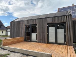 a building with two doors and a wooden deck at XCUBE Tinyhouse in Bad Dürrheim