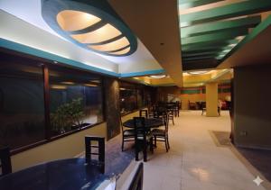 a dining area with tables and chairs in a restaurant at HillTop Hotel in Karachi