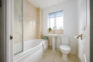 ein Badezimmer mit Badewanne, Toilette und Waschbecken in der Unterkunft Quai Des Pecheurs - With Views from Bedroom Overlooking the Harbour in Poole