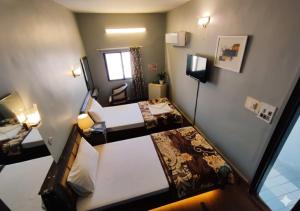 a hotel room with two beds and a window at HillTop Hotel in Karachi