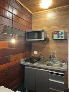 a kitchen with a sink and a microwave at Memoriá in Campos do Jordão