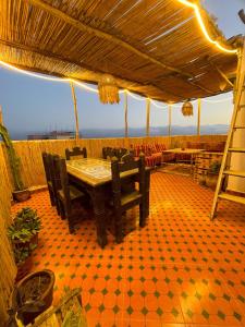 a dining room with a table and some chairs at Banana Surf Lodge in Tamraght Ouzdar