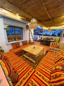 a living room with couches and a table on a balcony at Banana Surf Lodge in Tamraght Ouzdar