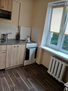 uma cozinha com um fogão, uma pia e uma janela em Уютный уголок em Narva mais 3 fotografias
