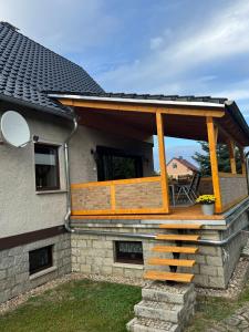 una gran terraza de madera en el lateral de una casa en FERIENHAUS ZUM HOLZMICHEL, en Thale