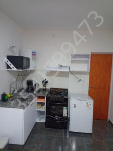 een kleine keuken met een fornuis en een koelkast bij sol y brisa in La Porteña