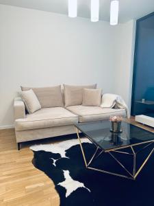 a living room with a couch and a glass table at Žvėrynas Apartment with jacuzzi in Vilnius