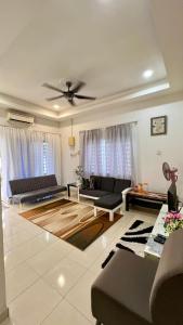 a living room with a couch and a ceiling fan at Homestay in Shah Alam