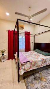 a bedroom with a canopy bed with red curtains at Homestay in Shah Alam +2 photos