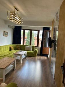 un soggiorno con un divano verde e un tavolo di Didi Park House къща с две спални a Sandanski