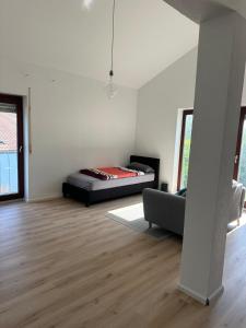 a white room with a bed and a couch at Apartment Lyvia - Platz und Ruhe für 5 in Karsau