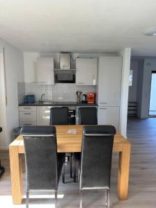 a kitchen with a wooden table and chairs at Apartment Lyvia - Platz und Ruhe für 5 in Karsau