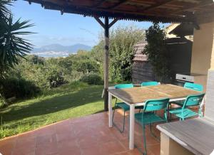 une table et des chaises en bois sur une terrasse dans l'établissement Appartement cosy vue mer, à Grosseto-Prugna