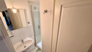 a bathroom with a sink and a toilet and a mirror at Les Cimes au cœur du Massif du Sancy in Le Mont-Dore