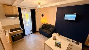 a living room with a couch and a tv on a wall at Les Cimes au cœur du Massif du Sancy in Le Mont-Dore +8 photos