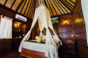 une chambre avec un lit avec moustiquaire dans l'établissement Secret Point Huts, à Nusa Lembongan 35 autres photos
